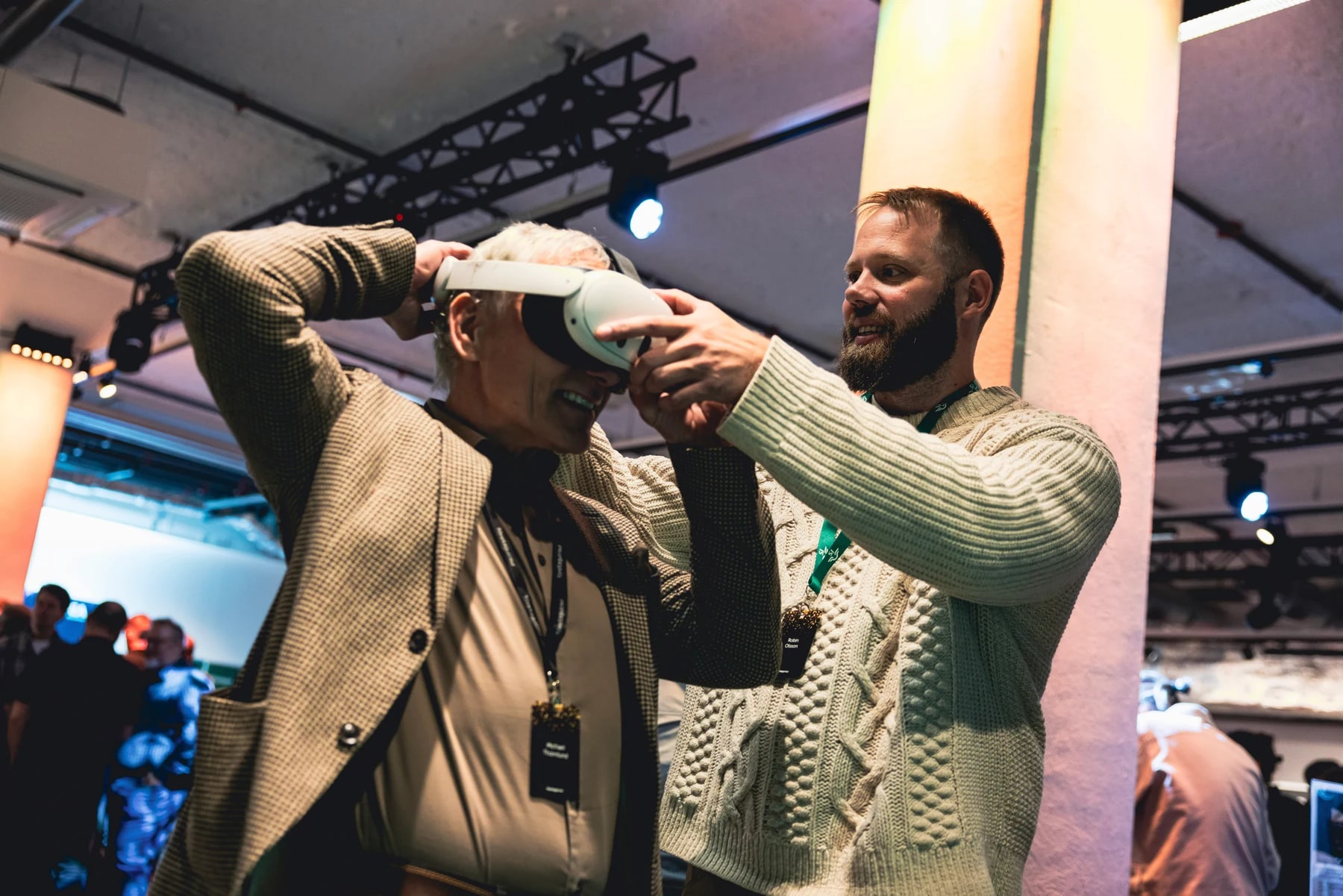 A guest putting on a VR headset with assistance at the event